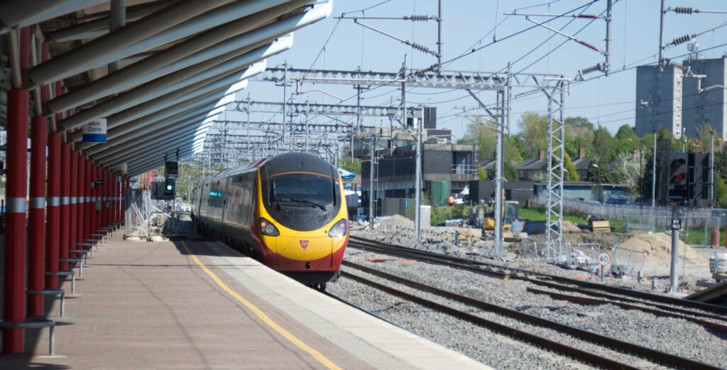 Electric railways help decarbonisation. Here an electric train leaves Rugby.